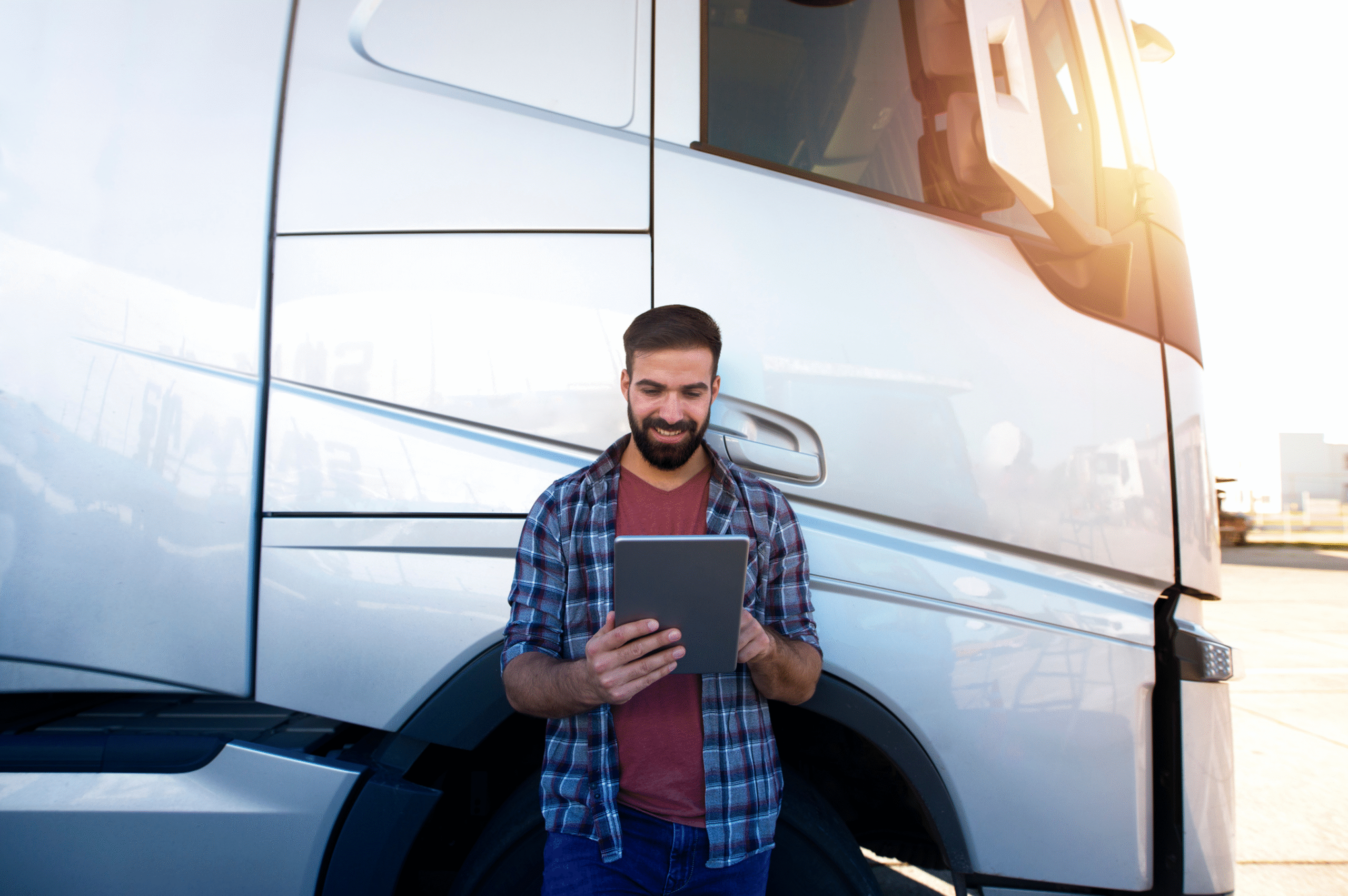 Professional driver using a tablet beside an HGV during a practical assessment